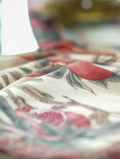 A close-up of a hand-painted napkin from the theme, showcasing the delicate artistry that goes into our custom linens.