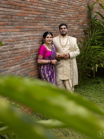 A classic portrait of the newly engaged couple against a simple brick wall, their traditional outfits providing a beautiful contrast.