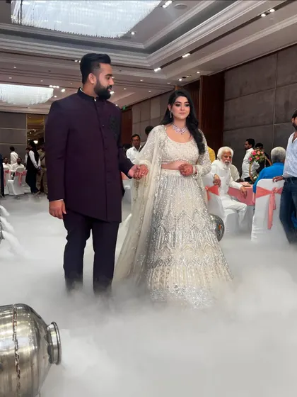 Another shot of the magical "walking on clouds" entrance. The couple holds hands as they navigate the ethereal smoke-filled path toward the stage.