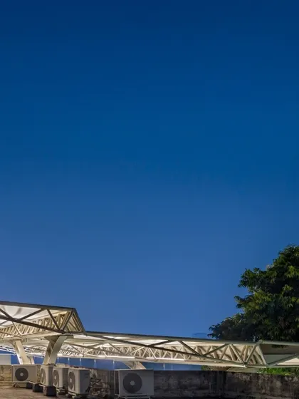 The cascading design of the tensile roof resolves drainage requirements while creating a dynamic form. The highest point is over the stage, stepping down towards the playfields.