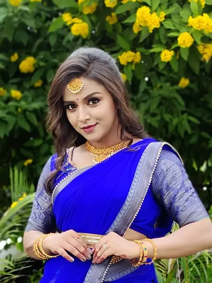 A close-up shot of a client in the blue half saree, showing her happiness and confidence.