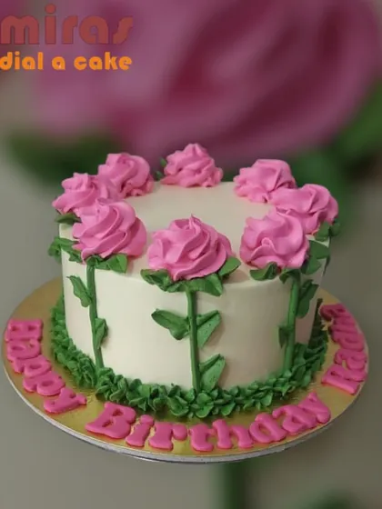 A simple white cake decorated with a garden of pink buttercream roses. This design is sweet, classic, and perfect for any floral-themed celebration.