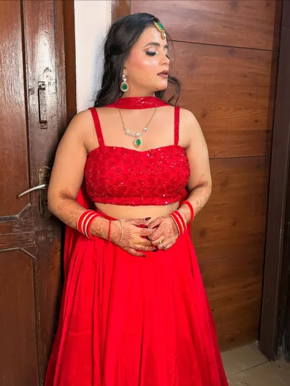 A profile view, showing the contrast of the green jewelry against the red outfit.
