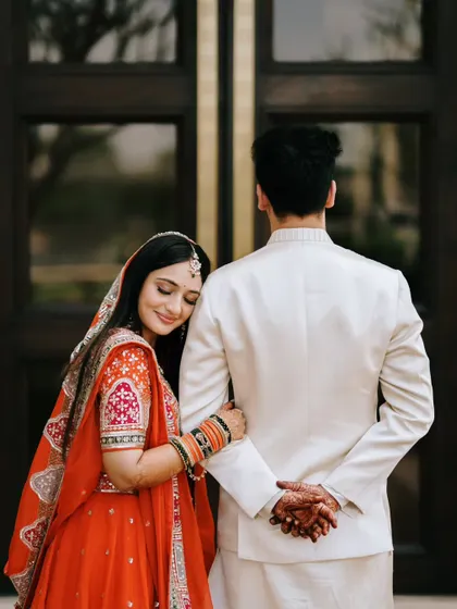A quiet, tender moment with the bride resting her head on the groom's shoulder. This back-facing pose creates a sense of intimacy and trust.
