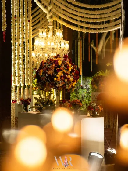 An artful, out-of-focus shot of a floral arrangement, with the bokeh of candles in the foreground. This captures the dreamy, romantic mood of the event.
