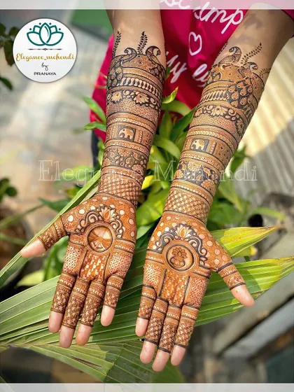 The full view of the bridal mehendi with the 'kalash' and 'gathbandhan' symbols, surrounded by intricate patterns and peacock motifs.