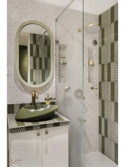 The attached bathroom for the young couple's room continues the olive green theme with patterned tiles and a unique boat-shaped basin, creating a cohesive and stylish suite.