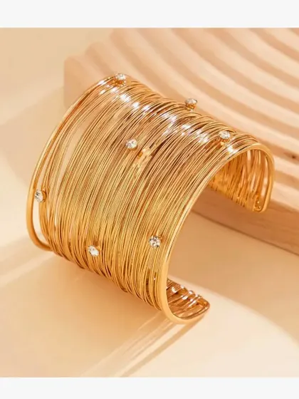 A product shot of the 18K gold-plated statement mesh cuff bangle, showing its intricate wire-work design.