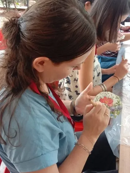 A participant painting her decoupage coaster, adding her own personal touch.