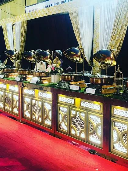 The long line of our illuminated gold buffet counters, ready for dinner service. This demonstrates the scale of events we can handle, ensuring a grand and impressive food presentation.