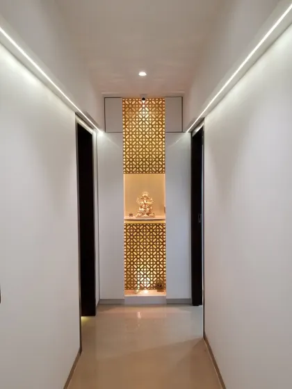 Sometimes, beauty lies in simplicity. This corridor design is clean and minimalist, leading to a beautifully designed temple niche at the end. The intricate jali screen is backlit to create a warm and divine glow.