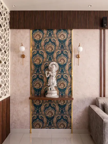A corner in the 'Muditā' living room dedicated to a Krishna idol, set against a rich paisley wallpaper and framed with brass inlay.