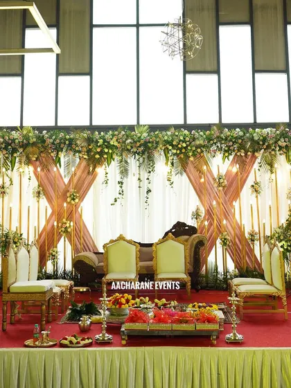 A sophisticated stage setup perfect for an engagement or reception. I used crisscrossing drapes in a soft peach color, accented with warm candle-like lights and lush floral arrangements on the top and sides.