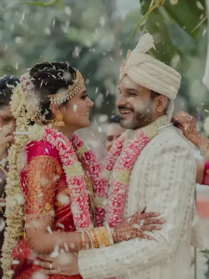 A candid, happy moment between the couple during their Varmala ceremony, surrounded by friends, family, and beautiful decor.