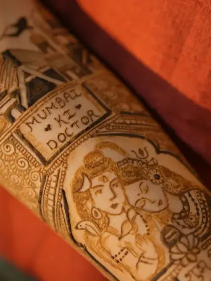 A detailed close-up of a bridal arm design featuring a Shiv-Parvati portrait and the phrase 'Mumbai ki Doctor', showcasing how we can blend divine blessings with personal stories.