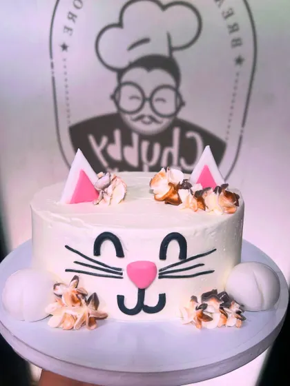 This cute cat cake is basically our spirit animal at the bakery. A simple white cake with a sweet hand-piped face, fondant ears, and fluffy buttercream details.