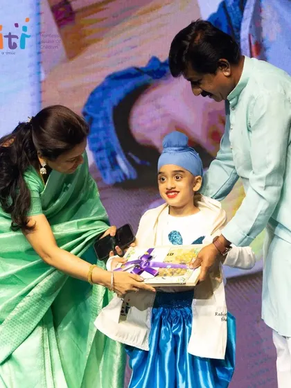 A proud graduate accepts his certificate and gift on stage.