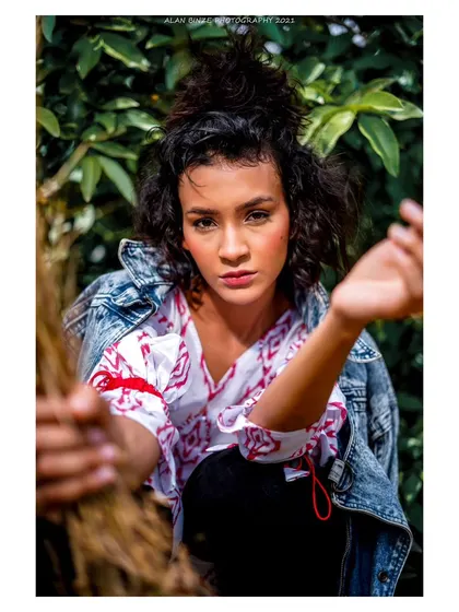 A captivating outdoor portrait. The close-up framing and the way she engages with the camera create a sense of intimacy and raw beauty.