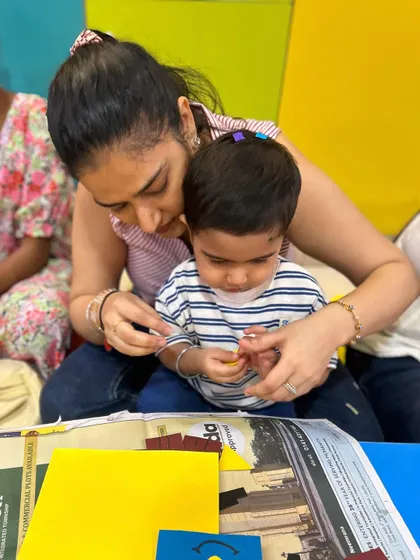 This close-up shot shows a mother guiding her child's hands, demonstrating the gentle instruction that helps build skills and confidence.