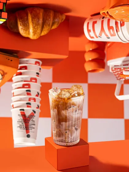 A full view of the playful, gravity-defying setup for Flyp Coffee. This shot combines an interesting checkerboard pattern with an unusual composition to create a memorable and energetic brand visual.