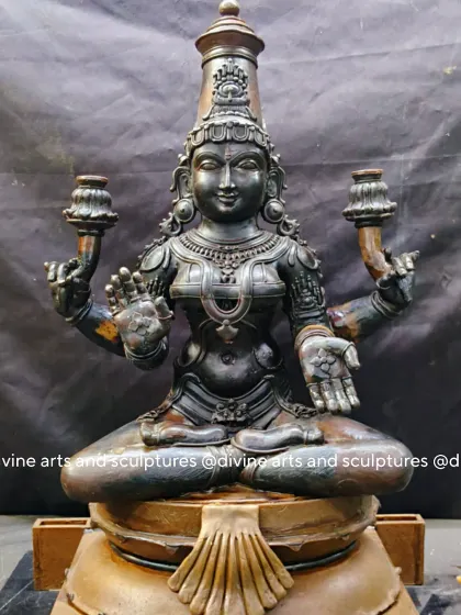The wax model of a four-armed Mahalakshmi, seated in a meditative posture. Her upper hands are shaped to hold lotuses, a symbol of purity and spiritual enlightenment.