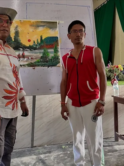 Posing with a completed landscape painting after a workshop at Gogamukh College Auditorium in Dhemaji.