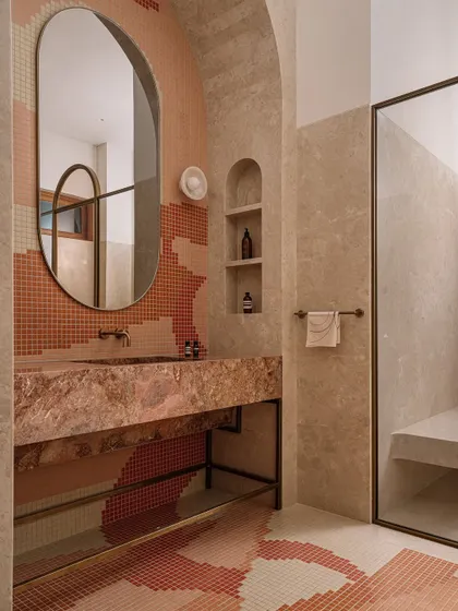 The parent's bathroom at Rehethaan is a swirl of playful pixel mosaics in earthy tones, crowned by a sculptural stone vanity.