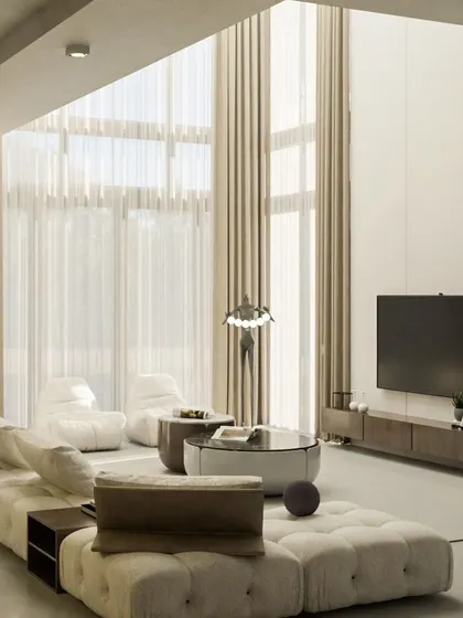 This sun-drenched, double-height living room is the definition of modern luxury. We used a long, modular sofa to anchor the vast space and kept the palette in soft, muted tones to create a serene and expansive atmosphere, letting the architecture and natural light take center stage.