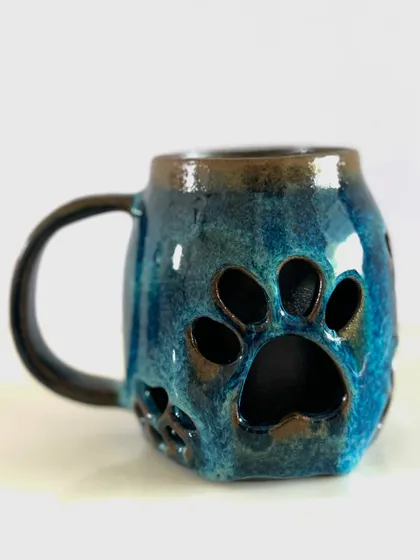 A full view of the double-walled paw mug, showcasing the pattern of prints around the form.