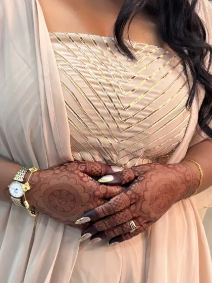 A gorgeous client showing off her beautiful mandala mehndi, which complements her elegant outfit perfectly.