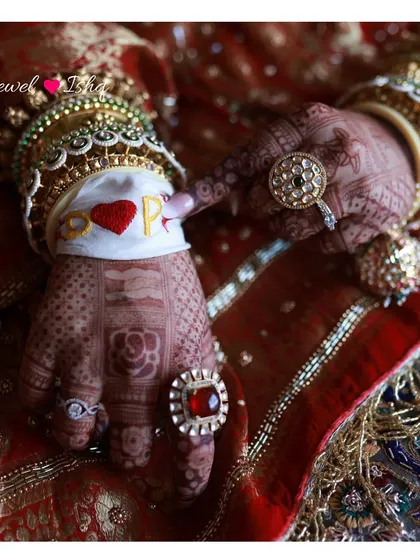 A close-up on the bride's hands, showing the custom 'D heart P' band, along with her stunning jadau rings and bangles. Personal touches make a look special.