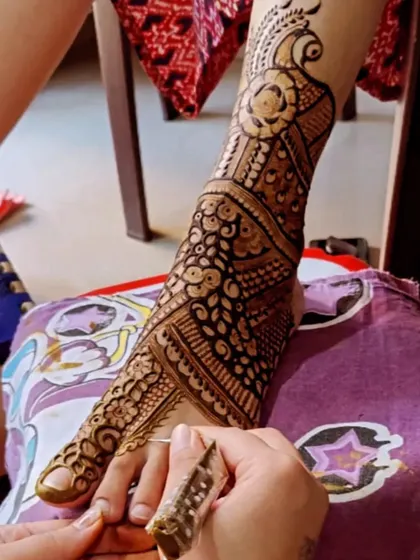 A behind the scenes look at my process. Here I am carefully applying a detailed design to a bride's foot using one of my henna cones.