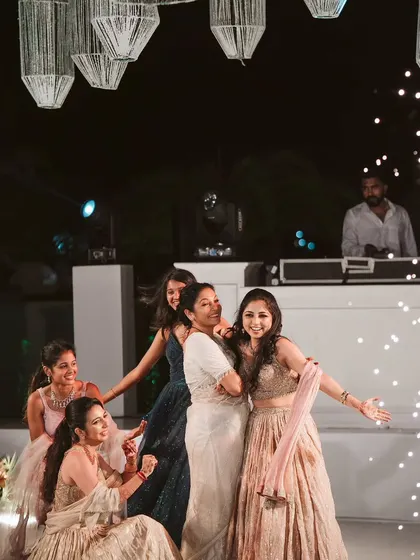 Guests light up the dance floor with sparklers. The hanging thread lanterns and DJ booth are part of a cohesive design for a fun and memorable Sangeet night.