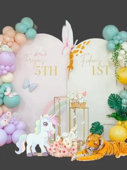 A creative split-theme backdrop for a joint birthday celebration, combining a magical unicorn theme for a 5th birthday with a wild jungle theme for a 1st birthday.