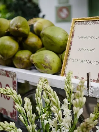A fresh coconut water cart, or "coco bar," at a Kerala-themed wedding, offering a refreshing and traditional welcome to guests.