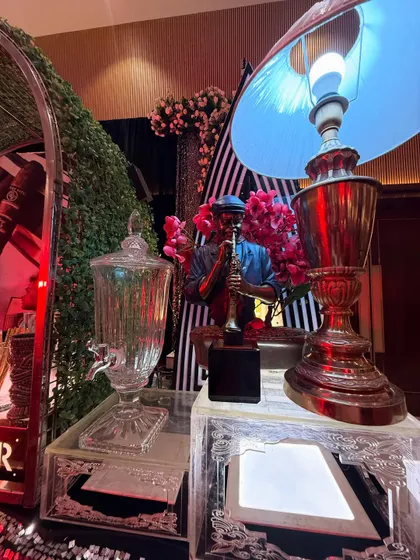A detailed shot of our bar decor, featuring a saxophonist statue, a vintage lamp, and a glass beverage dispenser.