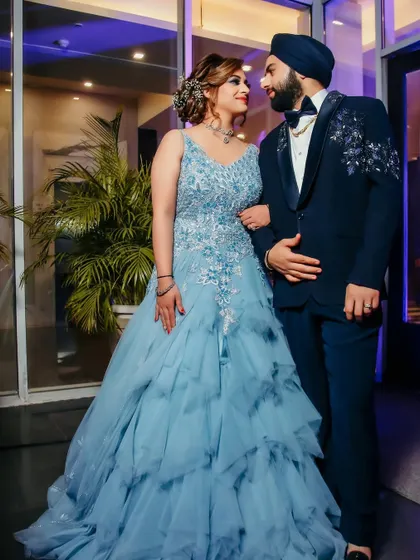 A loving portrait of the couple at their engagement. The bride's flowing blue gown and the groom's embellished tuxedo make for a stylish and romantic pair.
