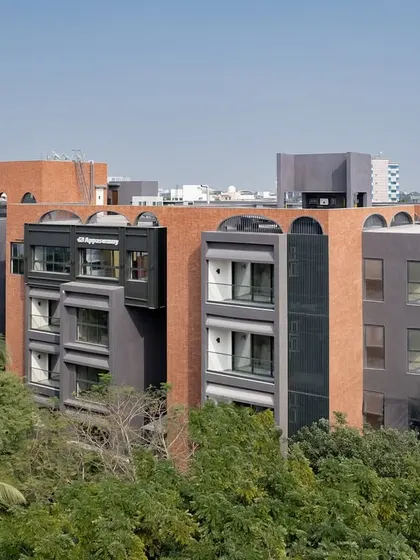 Aerial views of the ARCUS apartments in Chennai, showing how the building's form navigates the dense tree cover, creating a private oasis in the bustling T Nagar neighborhood.