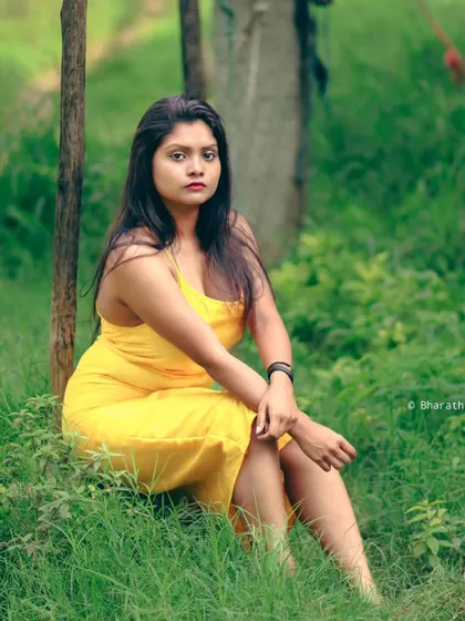 A seated portrait in a grassy area. The bright yellow dress stands out beautifully against the natural green tones.