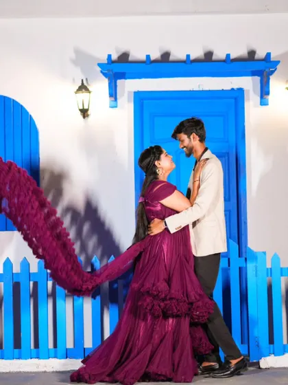 A beautiful shot with a flowing purple gown against a vibrant blue fence. The movement of the fabric adds a dynamic and elegant touch.