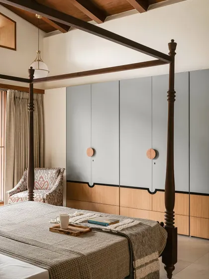 A different angle of the Kolam Pop master bedroom, highlighting the bespoke wardrobes that pair powdery grey with warm oak, and oversized circular pulls that act as modern Kolam strokes.