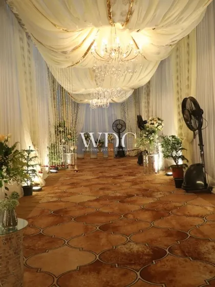 The entrance to the ivory-themed event, with flowing white and gold drapes, chandeliers, and lush floral arrangements, setting a tone of classic elegance.