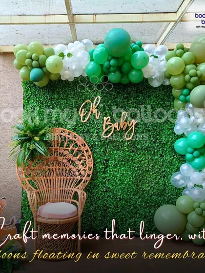 This "Oh Baby" shower setup had a natural and rustic feel. We used a wicker peacock chair as the centerpiece, set against a green hedge wall and framed by a beautiful organic balloon garland in shades of green and white.