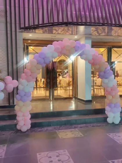 A closer view of the pastel balloon entrance arch. The mix of pink, purple, peach, and white balloons creates an inviting and festive entryway for guests arriving at the party venue.