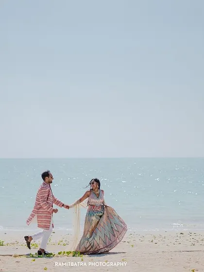 A happy couple runs along the beach in Khao Lak, Thailand, a perfect candid pre-wedding moment.