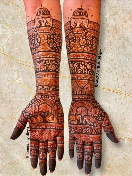 A grand design fit for the groom's mother. This full-arm mehendi features traditional motifs like swans, elephants, and peacocks, telling a story from the palm to the elbow.