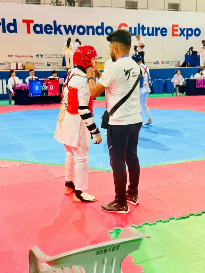 Adjusting my student's headgear before a match.