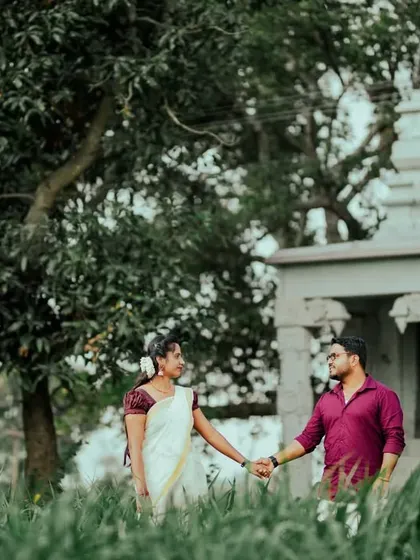 A pre-wedding photo capturing a quiet moment between a couple near a small temple, blending tradition with natural beauty.