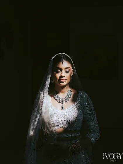 A study in light and shadow. This artistic bridal portrait uses a single sliver of light to illuminate the bride's face and jewelry, creating a dramatic and soulful image.