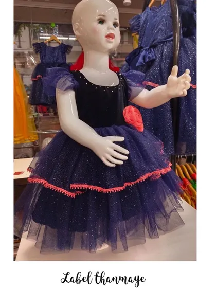 A navy blue party frock with pink lace trim and a floral accent.